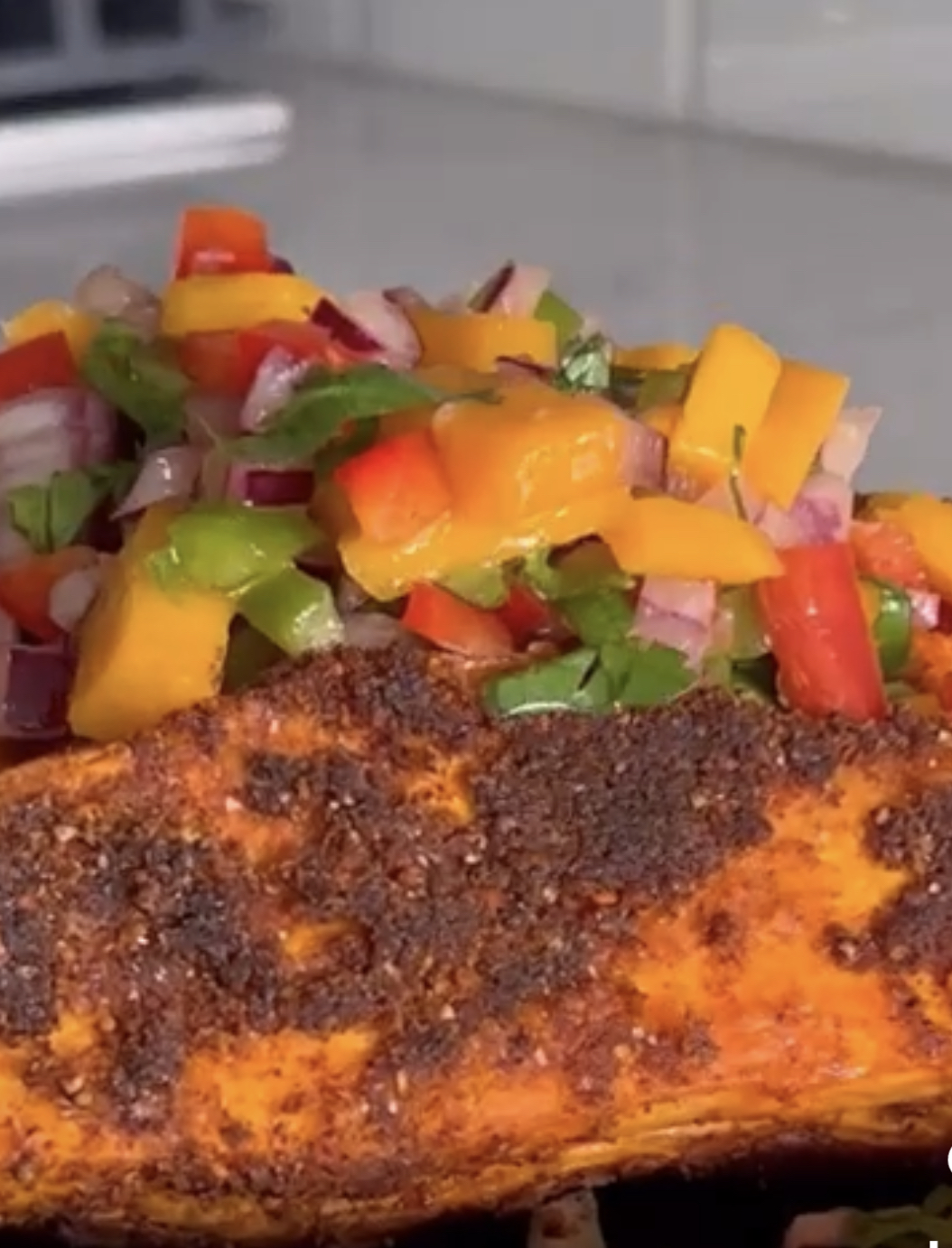 Blackened plant-based dish topped with fresh mango salsa